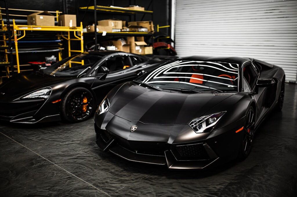 Sleek black sports cars parked in an industrial garage with modern design features.