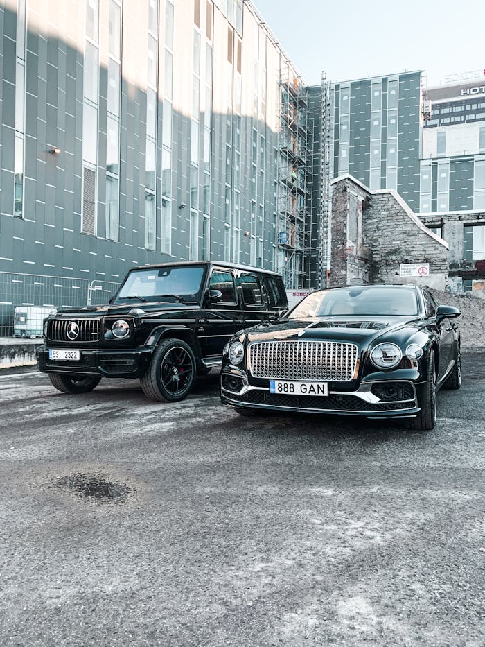 Luxury black cars parked on a concrete pavement outside a modern building in Tallinn, Estonia.